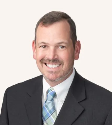 Headshot of a man smiling in a suit